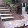Natural flagstone is on the concrete pad on the steps and deck. Premier Stone® is on the vertical surfaces. 